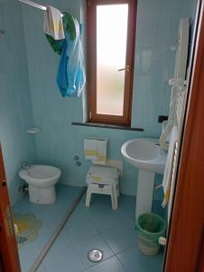 Baño azul con lavabo y aseo en Hotel Sottovento, en Sant'Egidio del Monte Albino