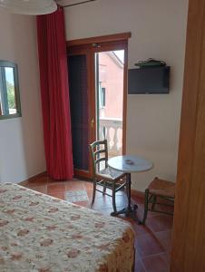 1 dormitorio con cama, mesa y ventana en Hotel Sottovento, en Sant'Egidio del Monte Albino