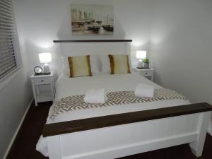 a bedroom with a large white bed with two night stands at Bronte Lodge, Wine Country Stay Hunter Valley with Games Room, Close to Town in Greta Main