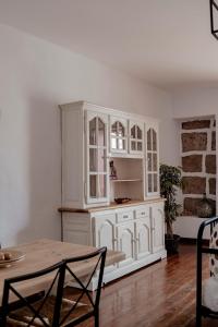 una cocina con armarios blancos y una mesa en una habitación en Apartamento Los Lirios, en Santa Brígida
