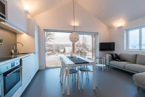 a kitchen and living room with a table and chairs at Bruksvallarna - Modern fjällstuga med panoramautsikt och WiFi in Bruksvallarna