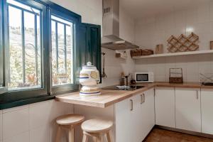 Apartamento Los Lirios في سانتا بريخيذا: مطبخ مع المقاعد و مزهرية على منضدة