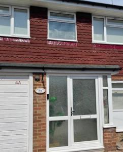 a red brick house with a white door at The Mews in Erith