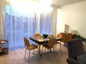 a dining room with a table and chairs and a window at African heritage Tervuren in Tervuren