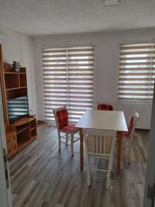 a dining room with a table and chairs and windows at AS guesthouse in Krževići