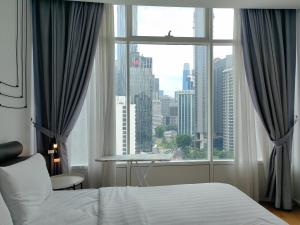 um quarto com uma cama e uma grande janela em Vortex Suites KLCC By Welt em Kuala Lumpur