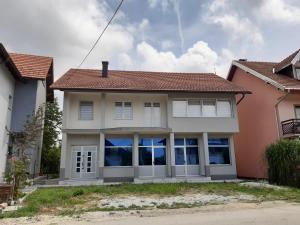 AS guesthouse في Krževići: بيت ابيض بسقف احمر