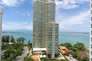 a tall building in front of the water at Family Suites at Mansion One by MAJ in George Town