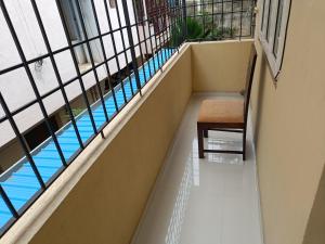 a balcony with a chair and a swimming pool at New Metro Serviced Apartment in Chennai