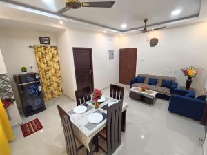 a living room with a table and a blue couch at New Metro Serviced Apartment in Chennai