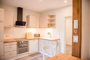 a kitchen with white cabinets and a white chair in it at Ferienwohnung Bad Vilbel in Bad Vilbel