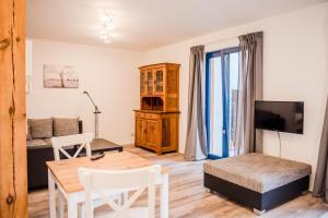 a living room with a dining room table and a television at Ferienwohnung Bad Vilbel in Bad Vilbel