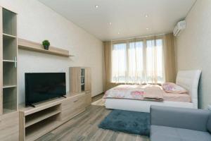 Schlafzimmer mit einem Bett und einem Flachbild-TV in der Unterkunft Видовая на 25 этаже in Kiew