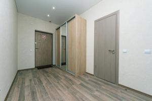 une chambre vide avec deux portes et du parquet dans l'établissement Видовая на 25 этаже, à Kiev