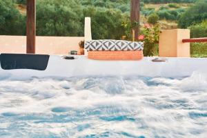 Mouri Villa في Mouríon: طاولة بيضاء مع وسادة على رأس موجة