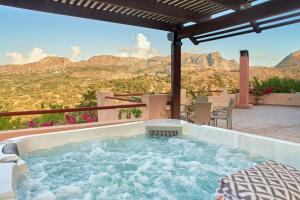 een hot tub op een patio met uitzicht op de bergen bij Mouri Villa in Mouríon