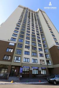 ein hohes weißes Gebäude mit vielen Fenstern in der Unterkunft Видовая на 25 этаже in Kiew