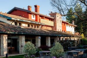 a building with tables in front of it at Elliot Osteria e dormire in collina in Manzano