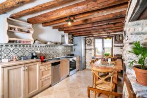 a kitchen with wooden ceilings and a wooden table at MAROYDA STONEHOUSE in Panayia