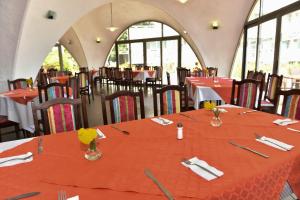a dining room with tables and chairs with red table cloth at Hotel Nona in Albena