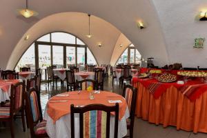 a restaurant with tables and chairs with red table cloth at Hotel Nona in Albena