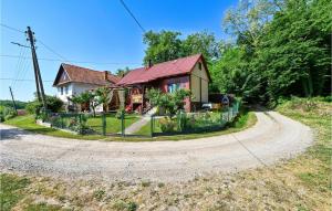 a house with a red roof on a dirt road at Cozy Home In Gornja Konjscina With Wifi in Hrašćina