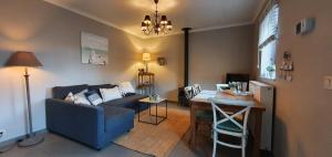 Guesthouse Biolleke في Boutersem: غرفة معيشة مع أريكة زرقاء وطاولة