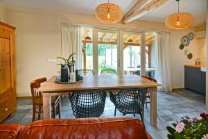 een eetkamer met een houten tafel en stoelen bij Vakantiehuis Dur Piepert in Eys
