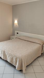 Ce lit se trouve dans une chambre blanche dotée d'un sol blanc. dans l'établissement Hotel La Cartiera, à Vignola