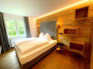 ein Schlafzimmer mit einem großen Bett und einer Holzwand in der Unterkunft Das Anja Alt Filzmoos in Filzmoos