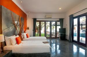 1 dormitorio con 2 camas y TV. en Villa Andaman, en Canggu