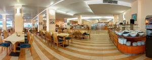 a restaurant with tables and chairs and a cafeteria at Hotel Slavuna in Albena