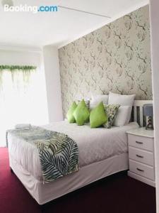 a bedroom with a large bed with green pillows at Dwengu Guest house in Margate