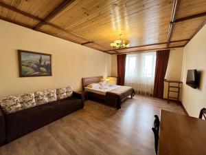 ein Wohnzimmer mit einem Bett und einem Sofa in der Unterkunft Taras Bulba in Kamjanez-Podilskyj