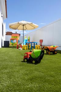 a yard with playground equipment and an umbrella at Ideal for family holidays, near beach and golf- Casa James in La Guirra