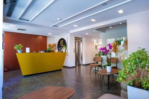 a lobby with a yellow counter and some plants at Hotel Semajo in Vlorë