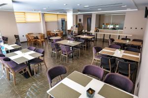 a dining room with tables and purple chairs at Hotel Semajo in Vlorë