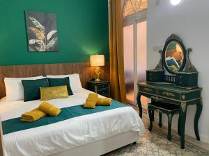 een slaapkamer met een bed met een spiegel en een tafel bij Parisio One Bedroom Maisonette in Sliema in Sliema
