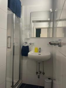 a white bathroom with a sink and a shower at Parisio One Bedroom Maisonette in Sliema in Sliema