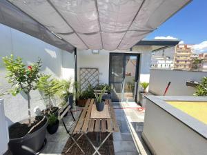 a balcony with a table and potted plants on it at Marranzanu Rooms in Santa Teresa di Riva