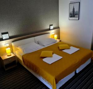 a bedroom with a large bed with two pillows on it at BoNiToS, SOBE-ROOMS in Slavonski Brod