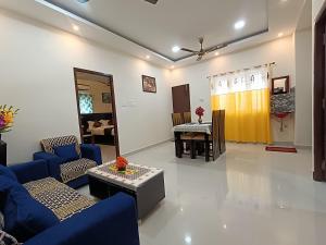 una sala de estar con sofás azules y una mesa. en New Metro Serviced Apartment en Chennai