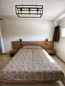 Schlafzimmer mit einem Bett und einem Kronleuchter in der Unterkunft Locazione Turistica El Sghirlo in Vidor