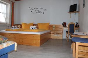 a bedroom with a wooden bed with two dogs on it at Pension Sonnleit´n - Urlaub mit Hund in Zwiesel
