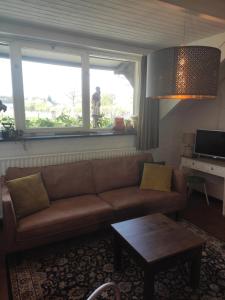 sala de estar con sofá marrón y mesa en Bergerhof de Stal, en Sevenum
