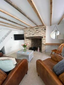 Blackberry Cottage - Newly renovated cosy cottage في Malborough: غرفة معيشة مع أريكة ومدفأة