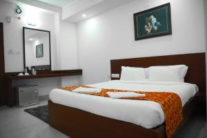 een slaapkamer met een groot bed in een kamer bij Harekrishna Hotel & Restaurant in Bhubaneshwar