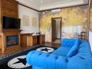 a living room with a blue couch and a fireplace at Taras Bulba in Kamianets-Podilskyi