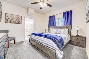 een slaapkamer met een bed en een raam met blauwe gordijnen bij Midtown Modern Farmhouse in San Antonio