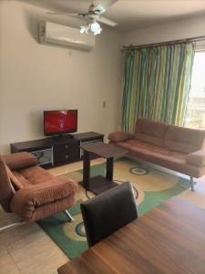 a living room with a couch and a tv at Chalet duplex in El Alamein